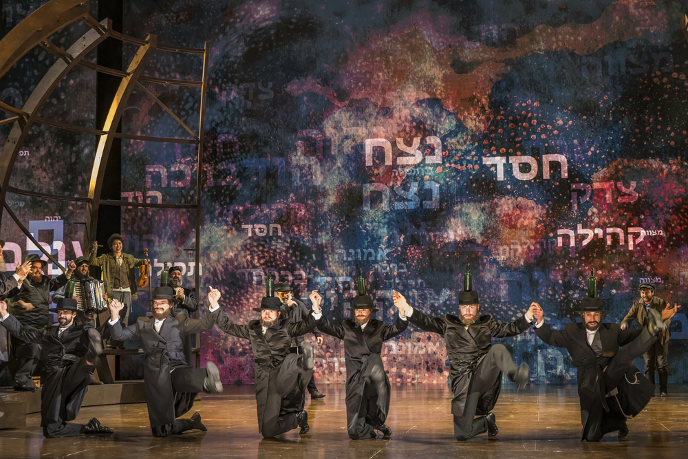 Performers balance bottles on their hats during the bottle dance in Fiddler on the Roof.
